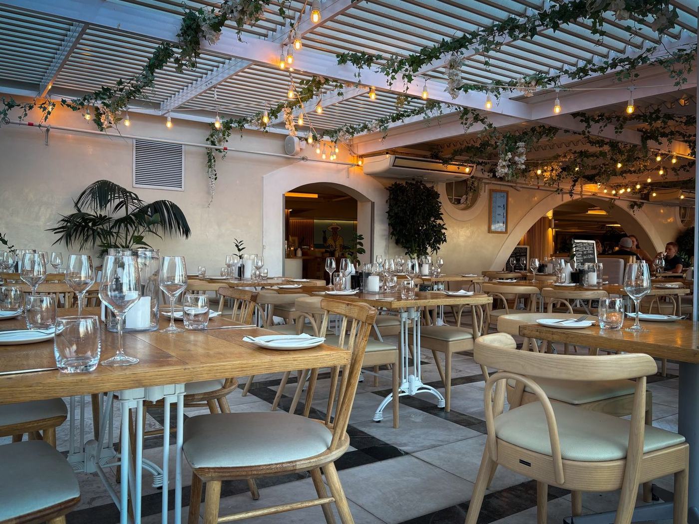Gastraum des Ristorante mit eingedeckten Tischen und warmem Licht